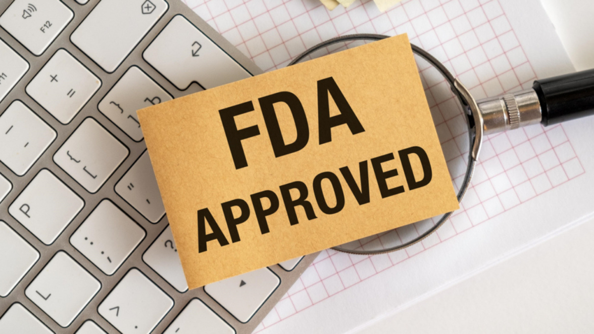 FDA approved sign displayed on laptop and documents during regulatory review.
