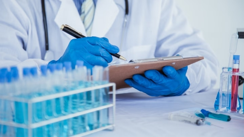 Clinician reviewing laboratory data beside test tubes in medical research setting