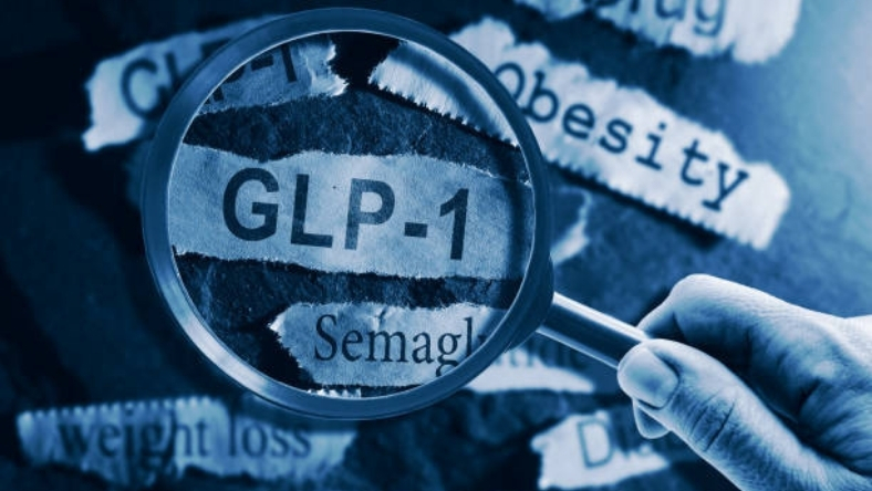Close-up of GLP-1 text under magnifying glass with obesity and diabetes terms